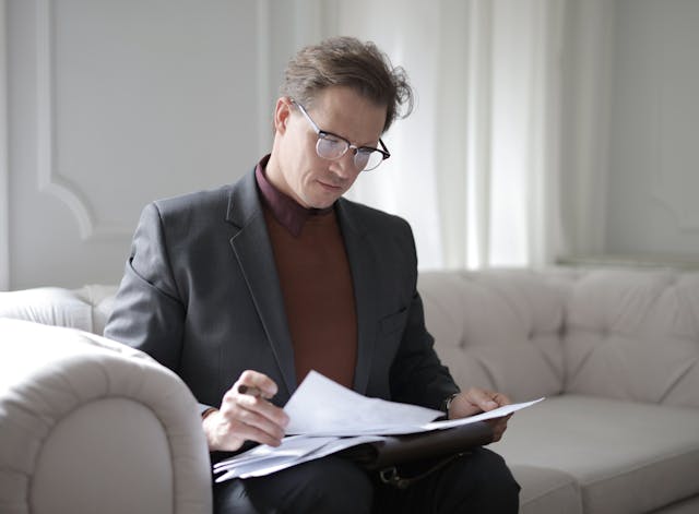 person%20reviewing%20documents%20while%20sitting%20on%20a%20couch%20in%20their%20office person%20reviewing%20documents%20while%20sitting%20on%20a%20couch%20in%20their%20office